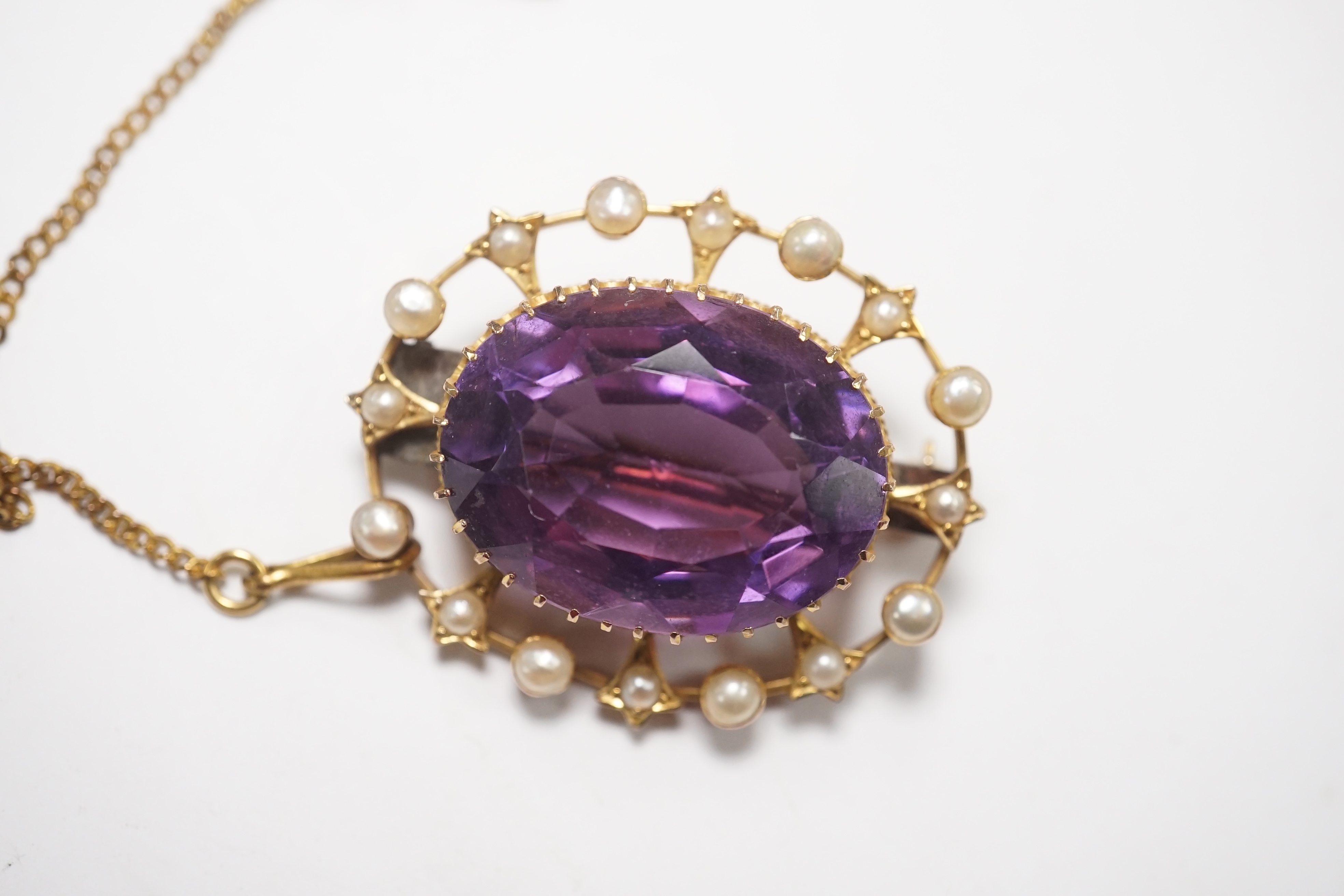 An Edwardian yellow metal, amethyst and split pearl set oval cluster brooch, 29mm, gross weight 7.2 grams. Condition - fair to good